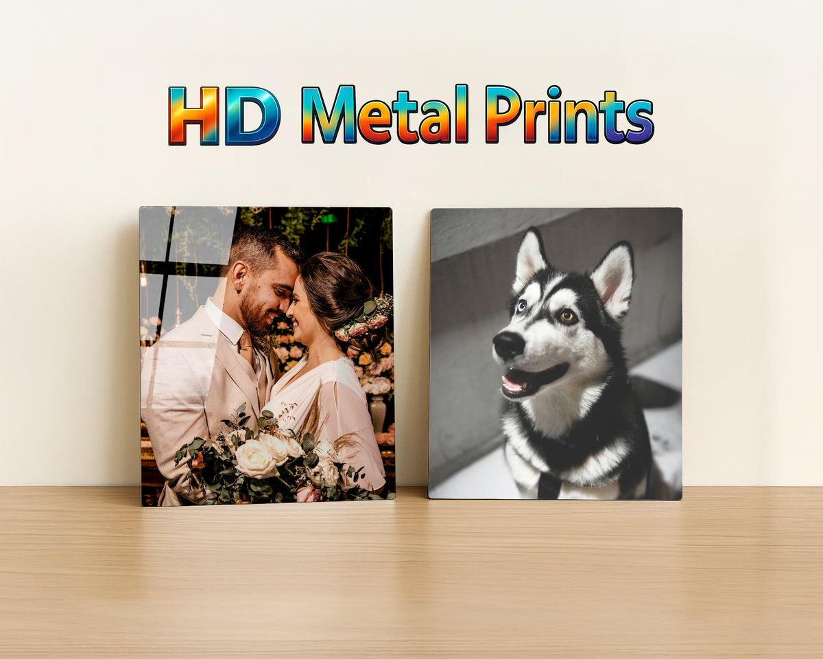 Two 8x10 custom photo metal prints displayed on a light wood surface against an off-white wall, with the text 'HD Metal Prints' above them. The left print shows a couple embracing with flowers, and the right print shows a black-and-white husky dog.