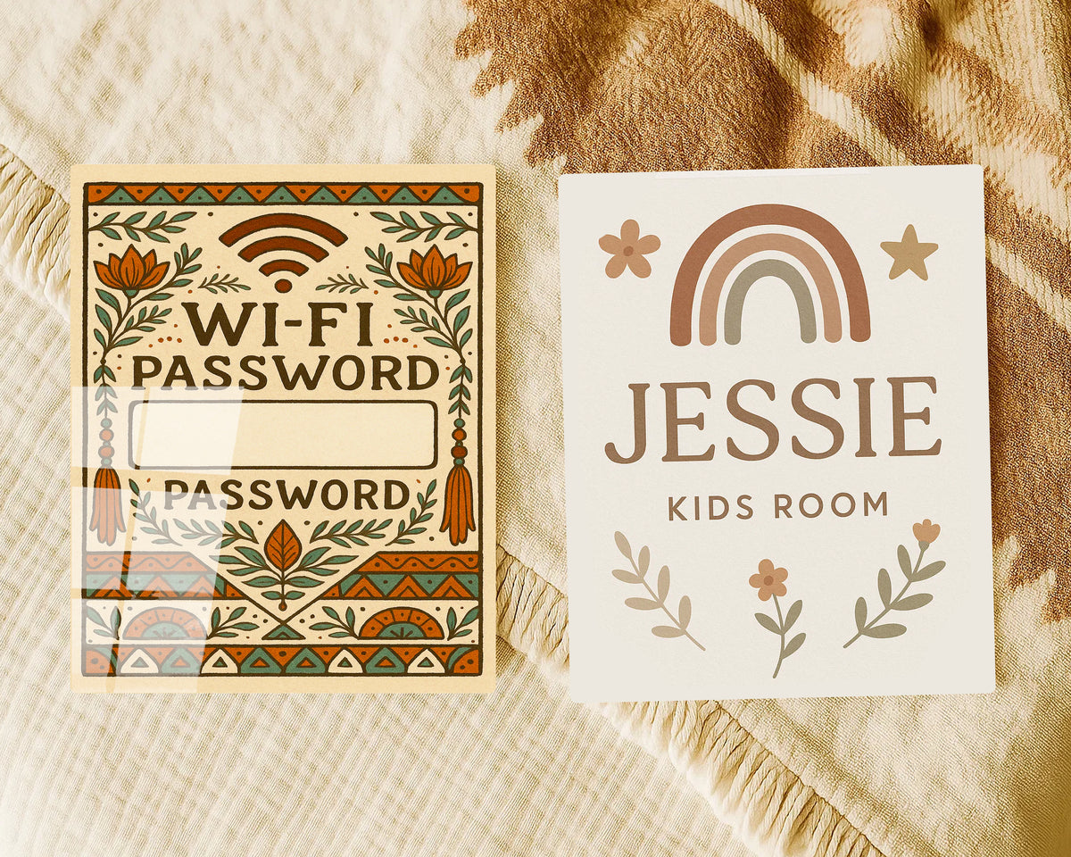 Two decorative printed cards laid flat on a beige textured blanket. The left card reads 'WI-FI PASSWORD' with floral and geometric border artwork and blank fields for the password.