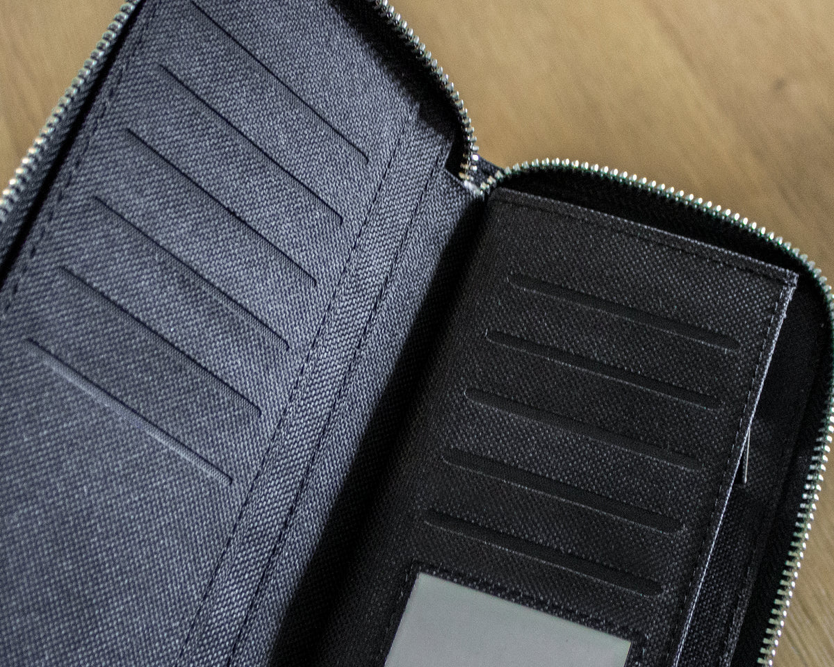 Close-up of a black canvas extured wallet on a wooden surface