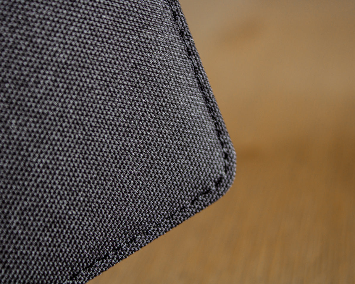 Close-up of a black canvas  fabric corner on a wooden surface