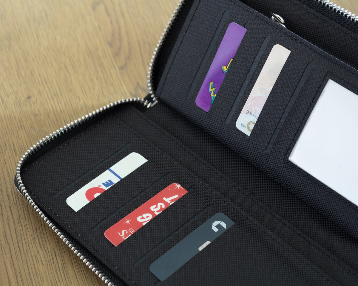 Black wallet with card holders on a wooden surface