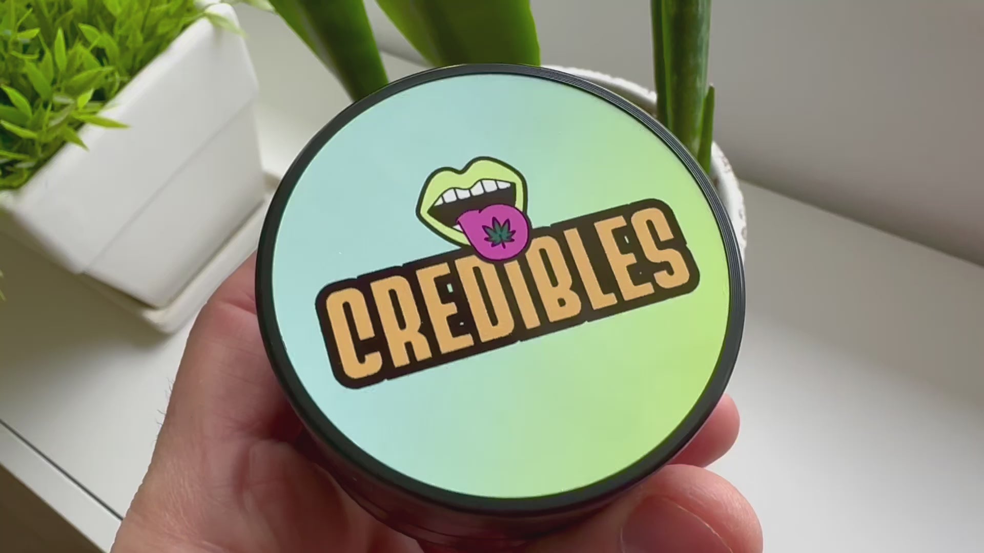 Custom photo herb grinder held in hand with a colorful personalized glossy lid and black zinc-alloy body.